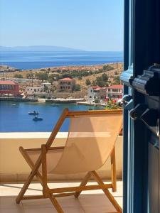 a chair on a balcony with a view of the water at Marina Castellana Studios in Halki