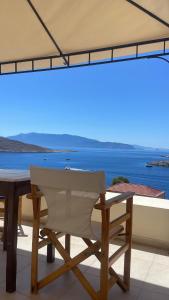 a table and chairs on a balcony with a view of the ocean at Marina Castellana Studios in Halki