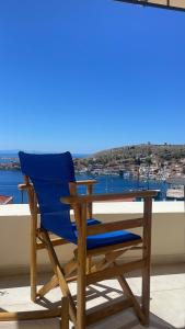 a blue chair sitting next to a table on a balcony at Marina Castellana Studios in Halki +119 photos