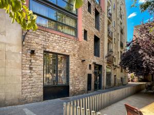 a brick building with a fence next to a street at Aspasios Born in Barcelona