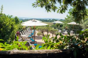 eine Reihe von Tischen und Stühlen mit Sonnenschirmen in der Unterkunft Villa Clodia Relais in Manziana