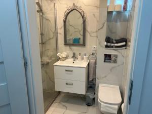 a bathroom with a sink and a shower and a toilet at Apartament Chanel Centrum in Malbork +17 photos
