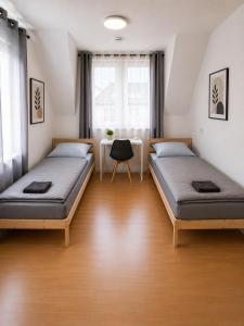 a room with two beds and a table in it at Wohnliches Apartment in Koblenz-Bubenheim in Koblenz +5 photos