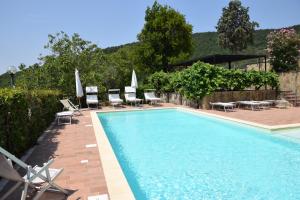 a swimming pool with lounge chairs and umbrellas next to at Agriturismo Colle Pu in Assisi