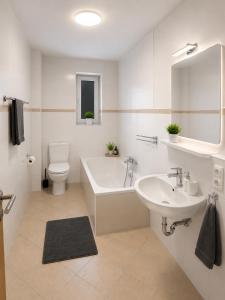 a bathroom with a tub and a sink and a toilet at Wohnliches Apartment in Koblenz-Bubenheim in Koblenz