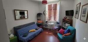 ein Wohnzimmer mit einer blauen Couch und Kissen in der Unterkunft Bastia-Room in Bastia