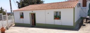 a small white and green building with two windows at Casa Dominique in São Pedro do Corval