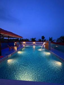 a swimming pool at night with a fountain at Ocean Kala Crest in Cheyūr
