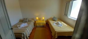 two beds in a room with two lights on them at Casa Dominique in São Pedro do Corval