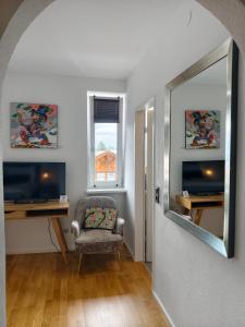 a living room with a chair and a mirror at Apartment Central Mutters Innsbruck in Innsbruck