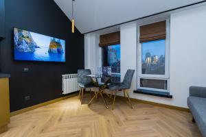 a dining room with a table and chairs and a tv on the wall at MYFREEDOM Premium Apartments near Khreshchatyk in Kyiv +199 photos