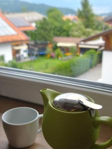 a green cup of coffee sitting on a table next to a window at Apartment Central Mutters Innsbruck in Innsbruck