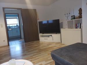 a living room with a flat screen tv and a wooden floor at Ferienwohnung Thielen in Badem