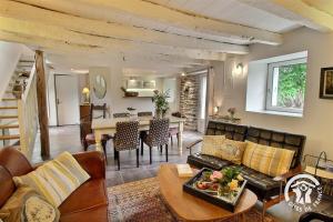 a living room with a couch and a table at Au charme de la forêt in Belle-Isle-en-Terre