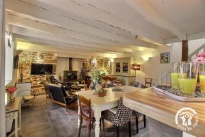 a kitchen and living room with a table and chairs at Au charme de la forêt in Belle-Isle-en-Terre
