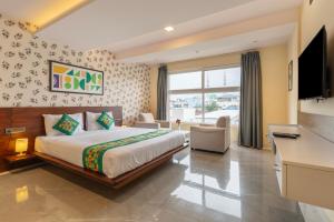 a hotel room with a bed and a television at Treebo Jaguar Comforts, 3 Kms From Mahatma Gandhi Park in Chikmagalūr +27 photos