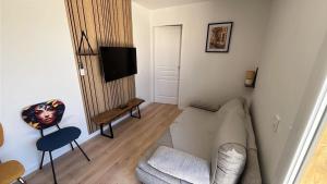 a living room with a couch and a tv at Le Container accèsPRM in Cognac