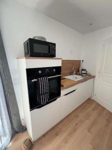 a kitchen with a microwave on top of a stove at Le Container accèsPRM in Cognac