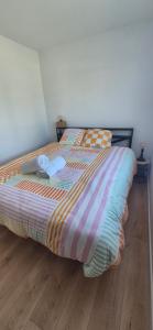 a bed with a striped comforter in a bedroom at Le Container accèsPRM in Cognac