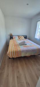 a bed in a bedroom with a wooden floor at Le Container accèsPRM in Cognac