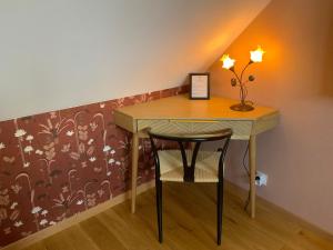 a small table with a chair in a room at Le Cap Saint Jacques Chambre d hôtes proche de bayeux à 15 mn idéal plages du débarquement in Putot-en-Bessin