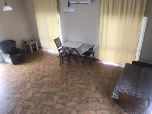 a living room with a table and chairs in it at Море і Сосни in Koblevo