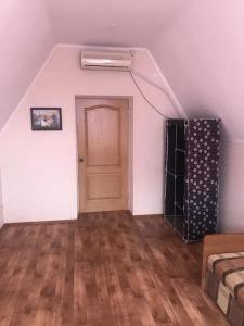 an empty room with a door and a wooden floor at Море і Сосни in Koblevo