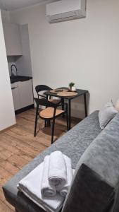 a room with a bed and a table and a kitchen at Domki nad jeziorem in Łasin +11 photos