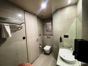 a small bathroom with a toilet and a sink at Hotel Cloud by ARIENA in Phundardih +9 photos