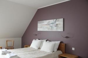 a bedroom with a bed with white pillows at Neeme Marina Questhouse in Neeme