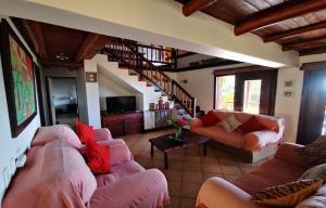 a living room with pink couches and a staircase at Vila Do Paraiso in Vilanculos