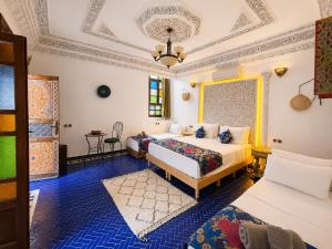 a bedroom with two beds and a couch at Riad Dar ElBellar in Fez +46 photos