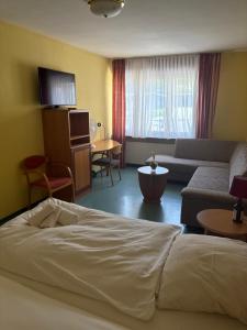 a hotel room with a bed and a couch at Hotel Restaurant Warndtperle in Völklingen