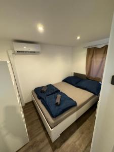 a small bedroom with a bed with a blue blanket at Sona Mobilhome M in Lido di Spina