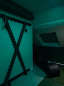 a door in a room with a black chair at Hédoné LoveRooms in La Chapelle