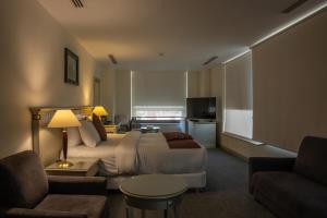 a hotel room with a bed and a couch at Armada Avenue Hotel Amman in Amman