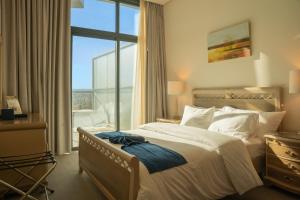 a bedroom with a large bed and a large window at Armada Avenue Hotel Amman in Amman