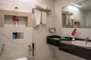a white bathroom with a sink and a mirror at Armada Avenue Hotel Amman in Amman +77 photos