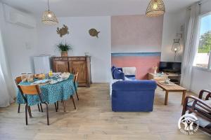a living room with a table and a blue chair at Le sémaphore in Saint-Cast-le-Guildo