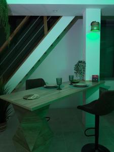 a dining room with a table and a blue light at Hédoné LoveRooms in La Chapelle