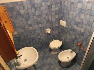 a blue tiled bathroom with a toilet and a sink at Cristallo del Gran Sasso in Forca di Valle +15 photos