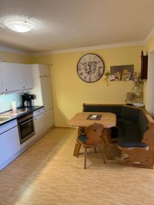 a kitchen with a table and a clock on the wall at Haus Hönigsgrub in Rinchnach