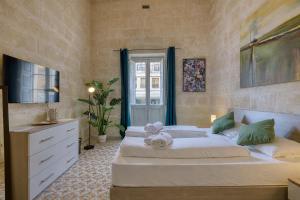 ein Schlafzimmer mit einem Bett, einer Kommode und einem Fenster in der Unterkunft Heart of Gozo - Modern Rooms in shared Apartment - Victoria D-Central opposite Duke Shopping Center in Victoria + 20 Fotos