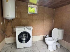 a bathroom with a washing machine and a toilet at Barisakho Mountain House in Chirdili