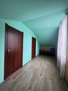 an empty room with a door and a wooden floor at Barisakho Mountain House in Chirdili
