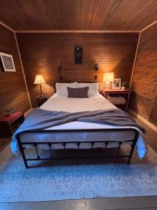 a bedroom with a large bed with a wooden wall at Wishart Point Lodge in Neguac