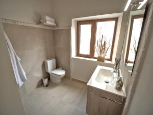 a bathroom with a toilet and a sink and a window at El Passeig Rural in Castalla