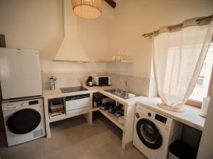 a kitchen with a sink and a washing machine at El Passeig Rural in Castalla +6 photos