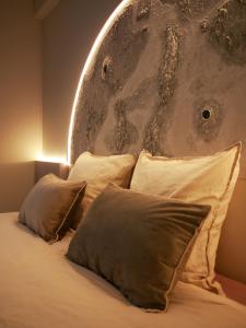 a bedroom with a bed with pillows and a wall at Galaxy Mood - 10 min Disney in Couilly-Pont-aux-Dames