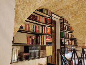 a room with bookshelves filled with books at B&B "Pulia Dimore Salentine" in Alessano